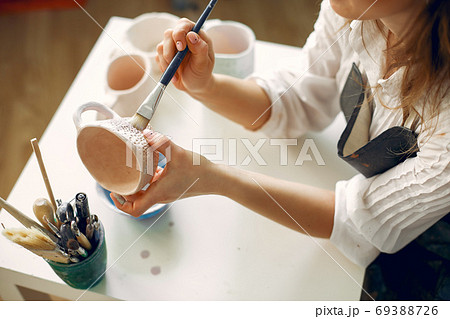 A young woman mpainting dishes in a pottery A young woman mpainting dishes in a pottery 69388726