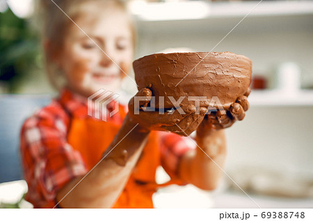 Girl making a vaze from a clay on a pottery's machine 69388748