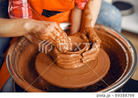 People making a vaze from a clay on a pottery's machine 69388766