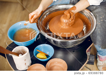 Girl making a vaze from a clay on a pottery's machine 69388780