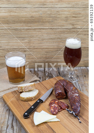 wooden board with sausage, cheese and beer glasses 69392139
