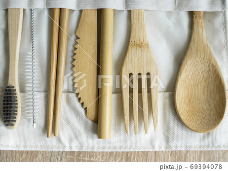 Eco friendly bamboo cutlery set in a case on a table. Zero waste concept. Set of bamboo cutlery in a case on a laying on a table. Spoon, fork, knife, toothbrush, tube and chinese sticks. 69394078