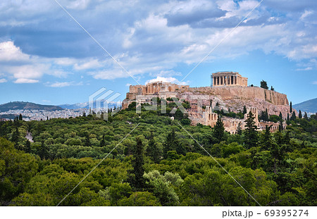 View of Acropolis hill and theater of Odeon in Athens, Greece from the hill of Philoppapos or Muses in summer daylight with great clouds in blue sky. 69395274