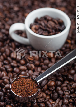 Fresh raw organic ground coffee powder in black steel scoop with white espresso cup Fresh raw organic ground coffee powder in black steel scoop with white espresso cup 69395910