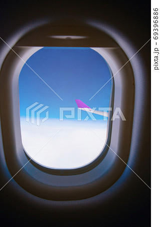 Beautiful scenic view sky through the aircraft window..Airplane interior with window view of blue sky and wing..Looking through window aircraft during flight in wing with a nice blue sky. Beautiful scenic view sky through the aircraft window..Airplane interior with window view of blue sky and wing..Looking through window aircraft during flight in wing with a nice blue sky. 69396886