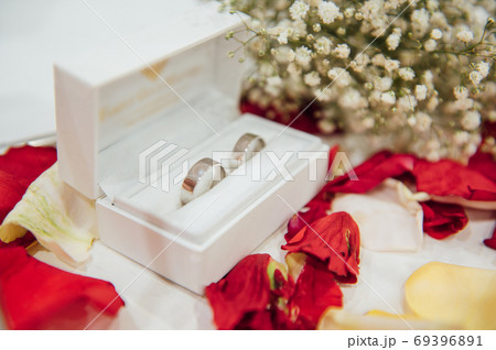wedding rings in a box with a bouquet of gypsophila 69396891