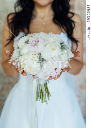 Bride holding white wedding bouquet of roses and love flower Bride holding white wedding bouquet of roses and love flower 69396983