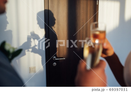 Bride and groom hold in their hands glasses with wine Bride and groom hold in their hands glasses with wine 69397031