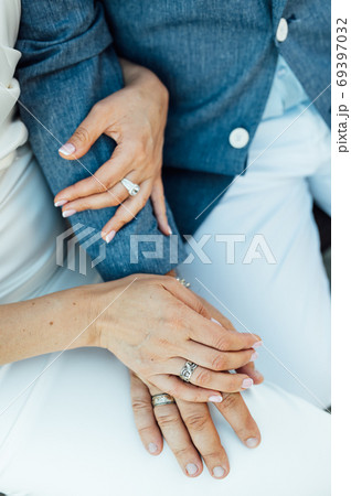 Close-up portrait of a bride and groom standing on the city street and lovely hugging Close-up portrait of a bride and groom standing on the city street and lovely hugging 69397032