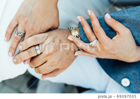 Close-up portrait of a bride and groom standing on the city street and lovely hugging Close-up portrait of a bride and groom standing on the city street and lovely hugging 69397035