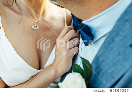 Close-up portrait of a bride and groom standing on the city street and lovely hugging Close-up portrait of a bride and groom standing on the city street and lovely hugging 69397037