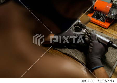 close-up. The jeweler makes a silver ring 69397443