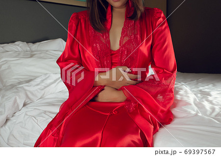 Irritable Bowel Syndrome or IBS. Asian woman in a silk nightgown 69397567