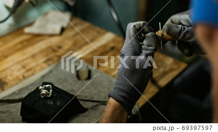 close-up. The jeweler makes a silver ring 69397597