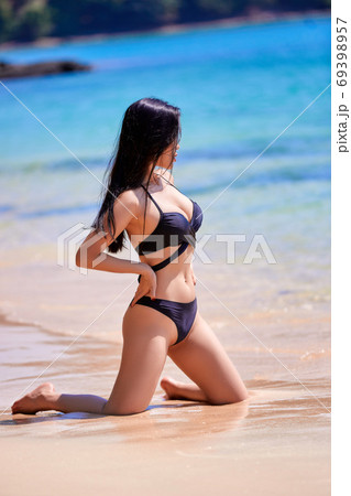 Beautiful asian woman enjoying on a tropical beach Beautiful asian woman enjoying on a tropical beach 69398957