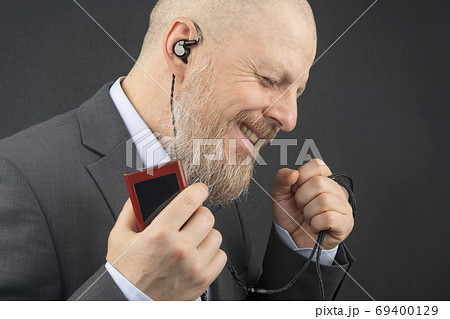 bearded business man likes to listen to his favorite music at ho 69400129