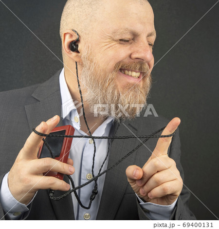 bearded business man enjoys listening to his favorite music from 69400131