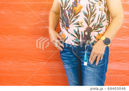 Mini portable alcohol gel bottle to kill Corona Virus(Covid-19) hanging on belt loop of woman' s jeans with plank background. New normal lifestyle. Health care concept. Selective focus on alcohol gel Mini portable alcohol gel bottle to kill Corona Virus(Covid-19) hanging on belt loop of woman' s jeans with plank background. New normal lifestyle. Health care concept. Selective focus on alcohol gel 69403046