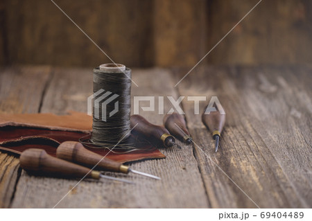 Leather craft tools on old wood table. Leather craft workshop. 69404489