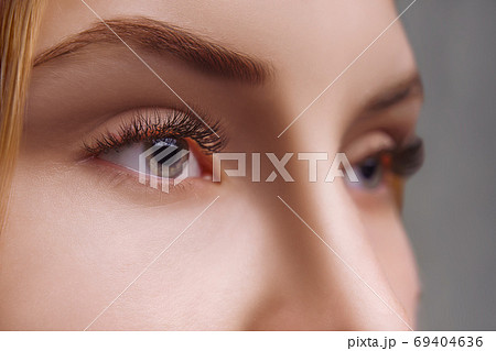 Eyelash Extension Procedure. Woman Eye with Long Eyelashes. Close up, selective focus. Eyelash Extension Procedure. Woman Eye with Long Eyelashes. Close up, selective focus. 69404636