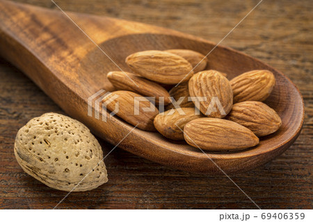 almond nuts on a wooden spoon almond nuts on a wooden spoon 69406359