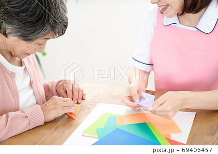 シニアのリハビリを一緒にする介護士 69406457