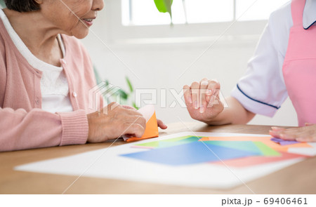 シニアのリハビリを一緒にする介護士 69406461