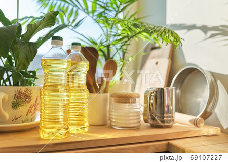 Kitchen utensils, sunflower oil on wooden table in pantry 69407227