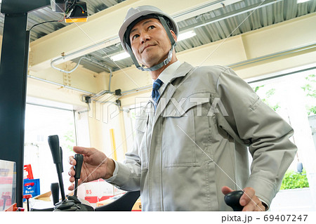 フォークリフトを運転するミドルの作業員 69407247