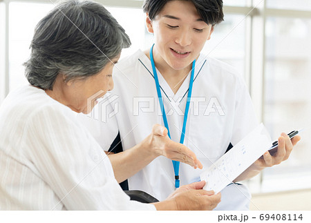 病院薬剤士と車椅子のシニア女性 69408114