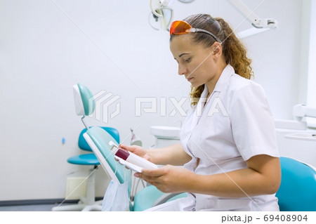 Serious female dentist doctor reading annotation of medicine 69408904