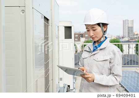 室外機を点検する女性作業員 69409401