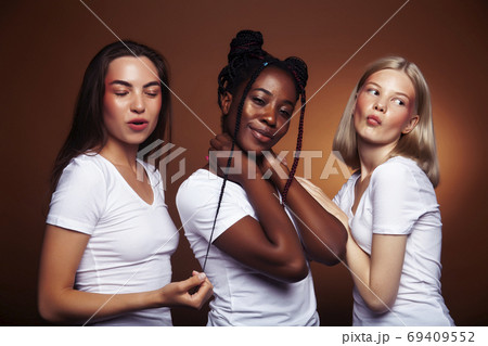 young pretty asian, caucasian, afro woman posing cheerful together on brown background, lifestyle diverse nationality people concept 69409552