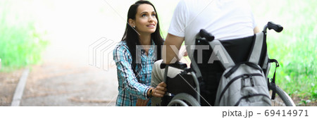 Disabled couple in love on a walk in park portrait. Wife looks at her husband in love with eyes 69414971