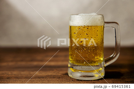 Glass of Beer on Table. Drinking Beer at Home or Cafe at Day Glass of Beer on Table. Drinking Beer at Home or Cafe at Day 69415361