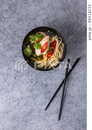 Spicy asian soup on vertical gray background Spicy asian soup on vertical gray background 69418233