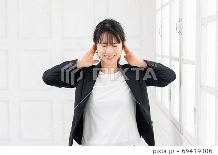 聞き耳をたてる若いビジネスウーマン 69419006