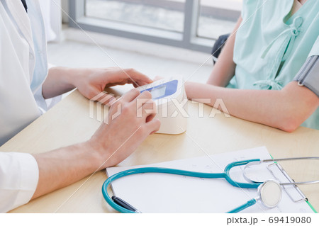 A doctor is examining the heartbeat of the patient 69419080