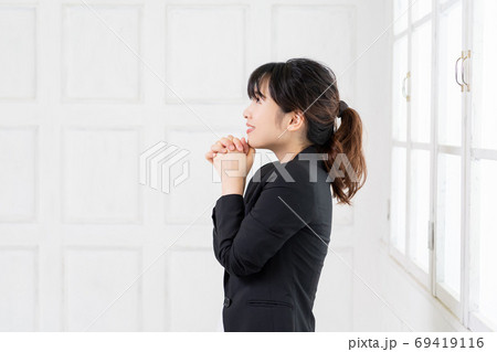 お願いのジェスチャーをする若いビジネスウーマン 69419116
