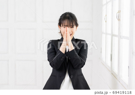 お願いのジェスチャーをする若いビジネスウーマン お願いのジェスチャーをする若いビジネスウーマン 69419118