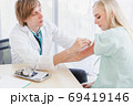A doctor disinfects on arm's skin before injection 69419146