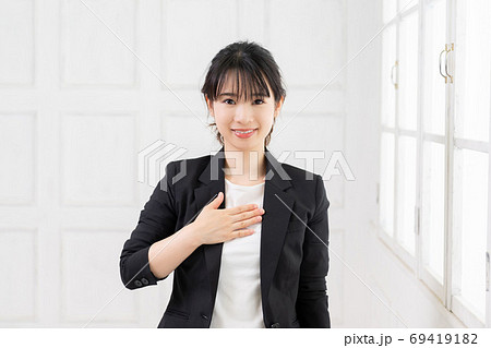 胸に手を当てる若いビジネスウーマン 69419182