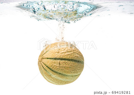 Cantaloupe melon splashing into water isolated on white background Cantaloupe melon splashing into water isolated on white background 69419281