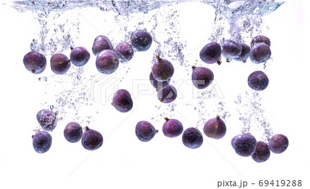 Fresh figs falling into the water isolated on white background. Food photography. 69419288