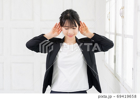 聞き耳をたてる若いビジネスウーマン 69419658