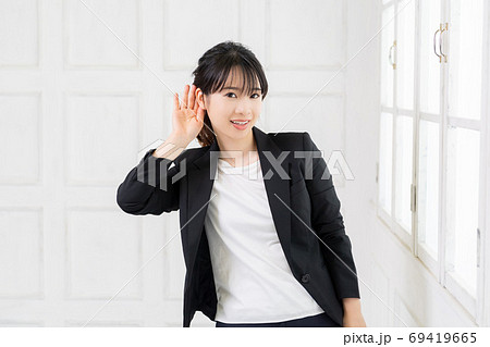 聞き耳をたてる若いビジネスウーマン 聞き耳をたてる若いビジネスウーマン 69419665