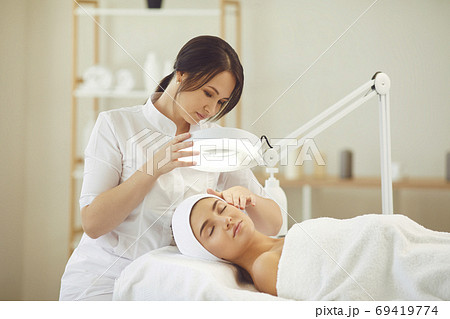 Relaxed young woman enjoying professional skincare procedures in modern beauty salon Relaxed young woman enjoying professional skincare procedures in modern beauty salon 69419774