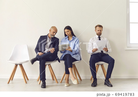 Group of business people sitting with official reports and waiting for directors invitation 69419783