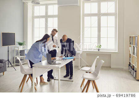 Team of office employees analyzing data reports or dealing with software problems 69419786