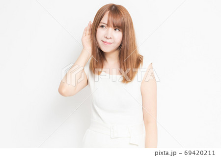 聞き耳をたてる若い女性 聞き耳をたてる若い女性 69420211